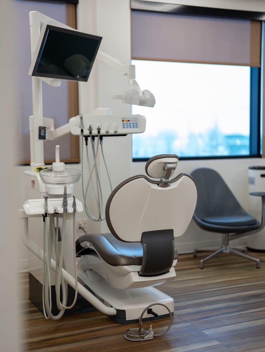 Orthodontic treatment chair and overhead screen in a bright treatment room