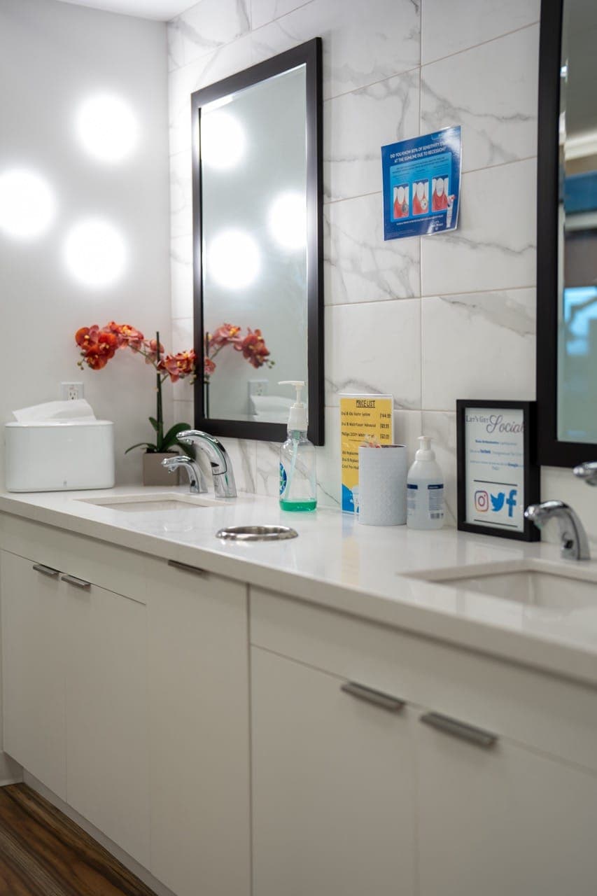 Patient sink area with mirrors and a white counter